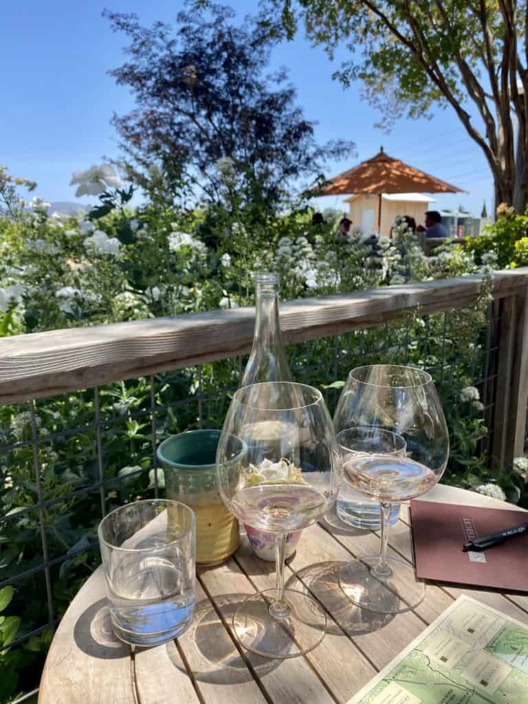 Wine glasses on a table in the garden of a winery called Saintsbury in Napa