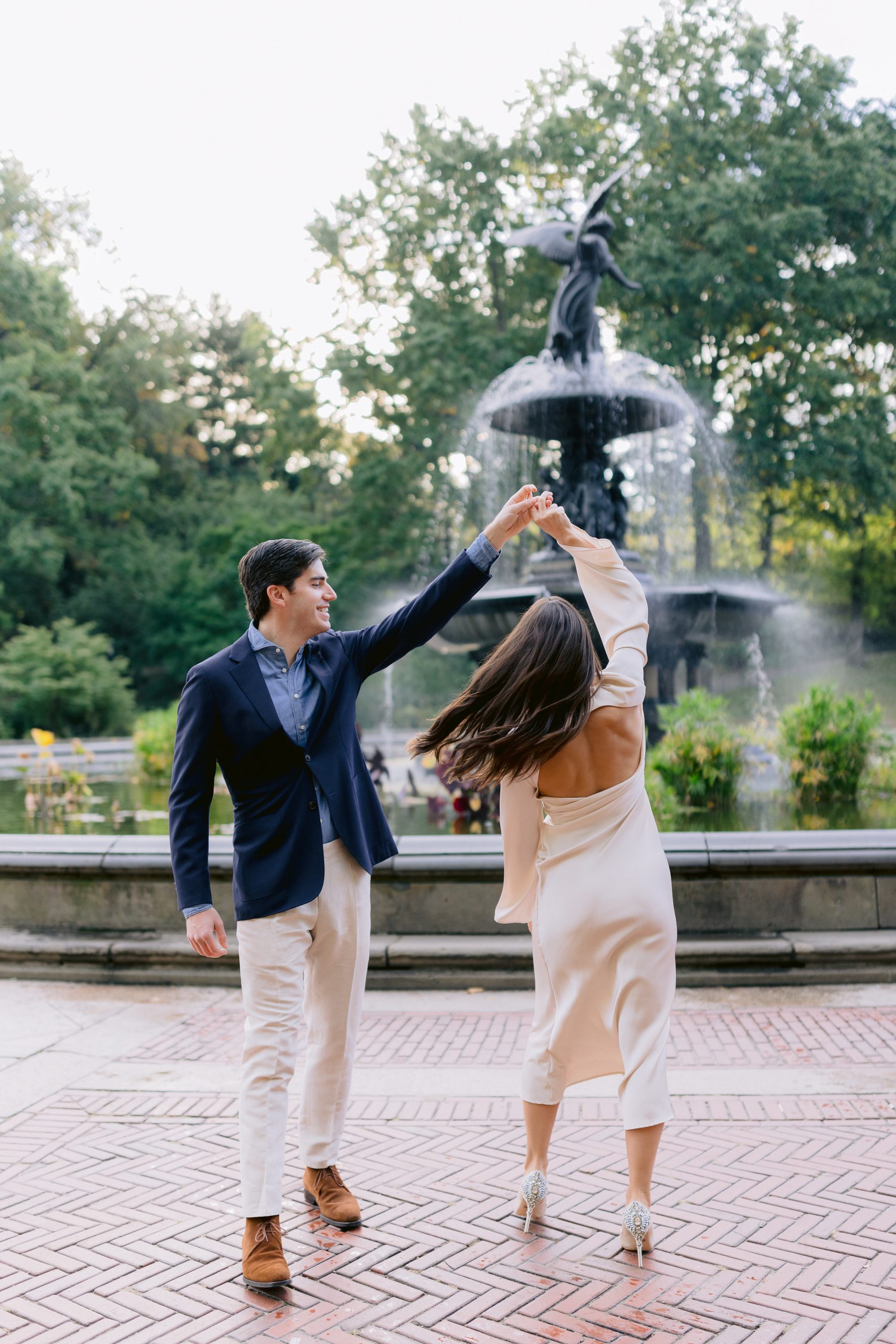 Ashley and her husband dancing in front of Bethesda Fountain during their 7:30 AM sunrise engagement photoshoot.
