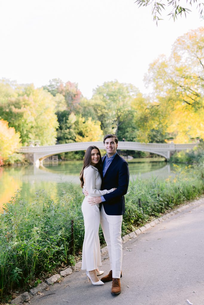 A romantic engagement portrait on the scenic Bow Bridge with the Central Park lake in the background.