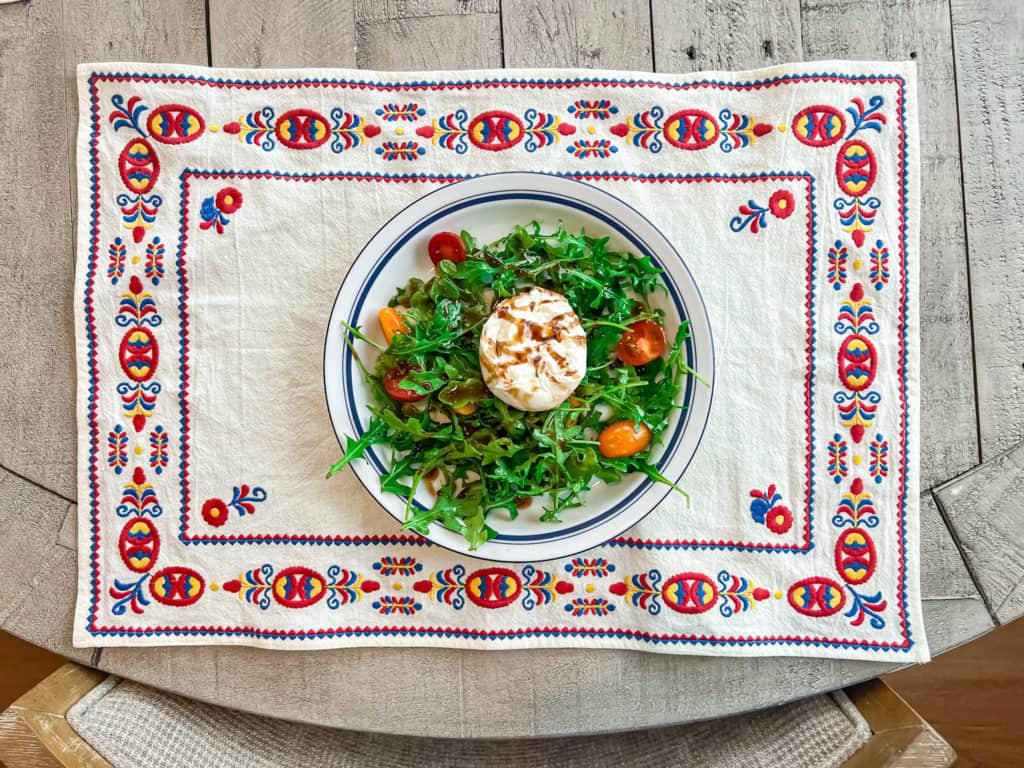 Burrata and arugula salad recipe plated nicely.