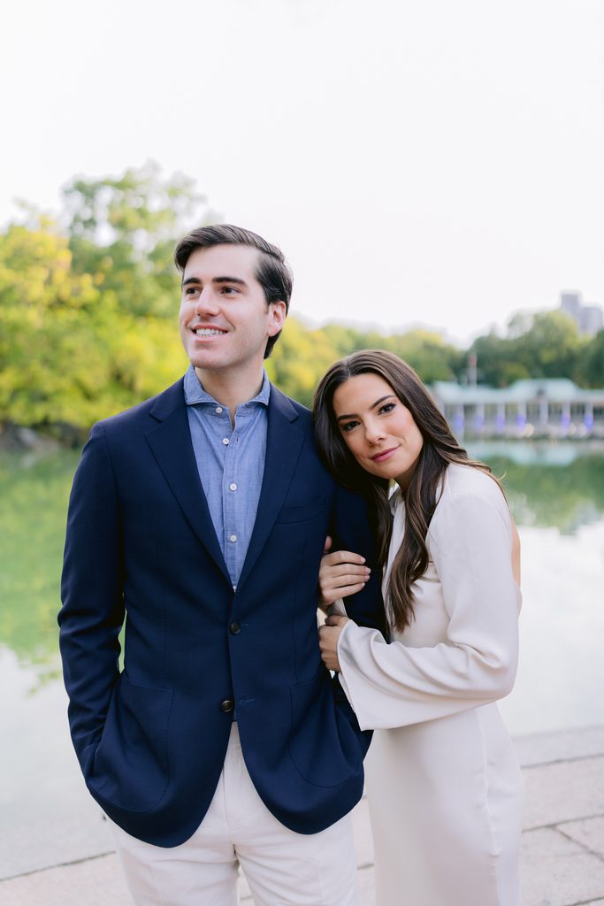 Couple posing with the iconic Loeb Boathouse and lake in the background during their NYC engagement shoot.