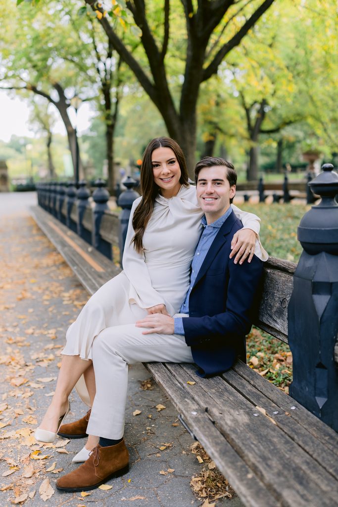 A candid moment of a couple sitting on a classic park bench at The Mall during a sunrise engagement session.