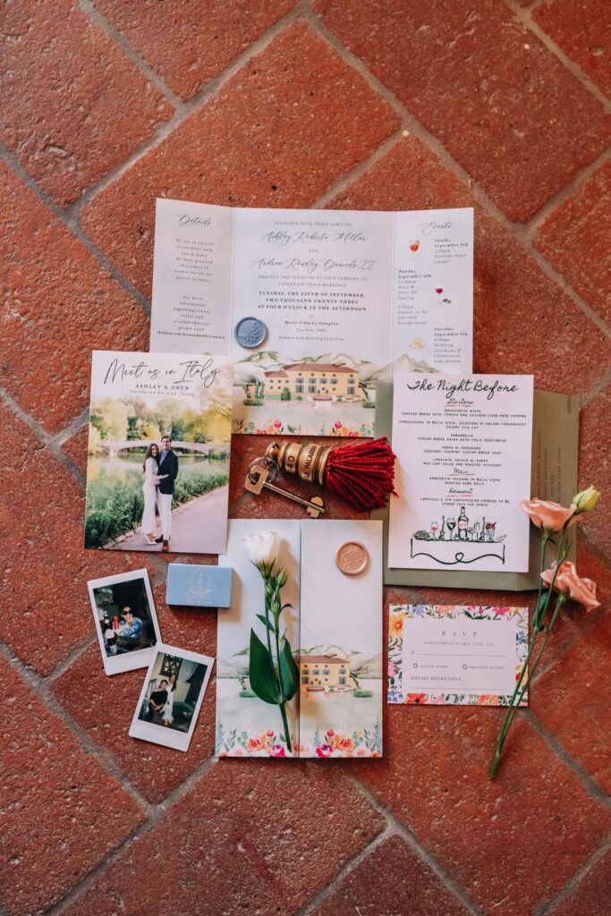 A detailed shot of a bespoke watercolor wedding invitation for a destination wedding in Italy laid on a red table.