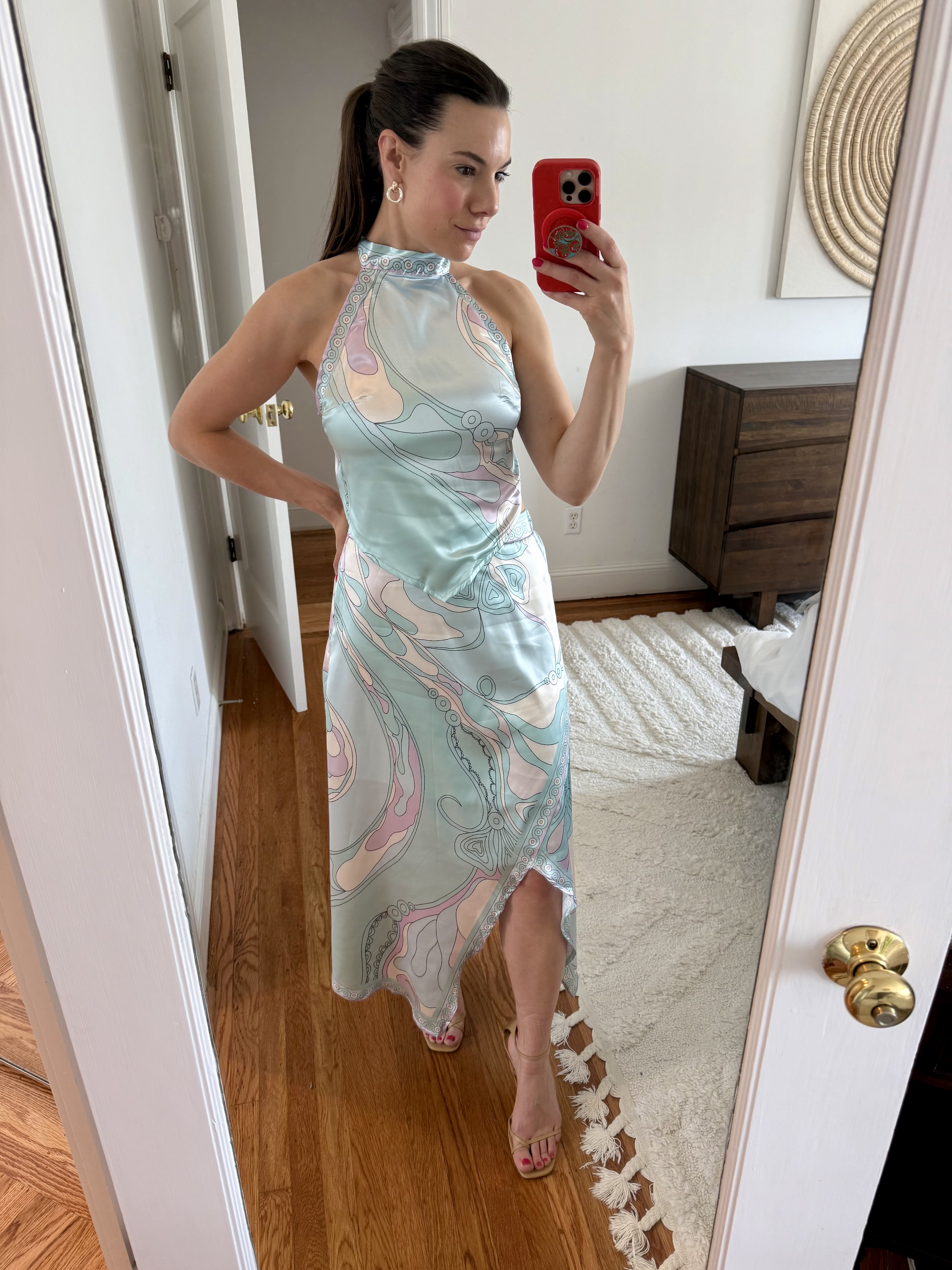 Full-length shot of a woman wearing a colorful, geometric Pucci-style print two-piece set for a vacation look.