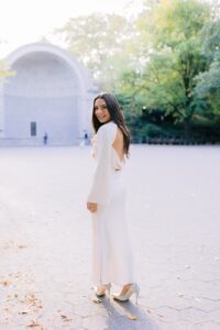 Ashley Miller Daniels, a San Francisco tech professional and style blogger, smiling in a white dress.