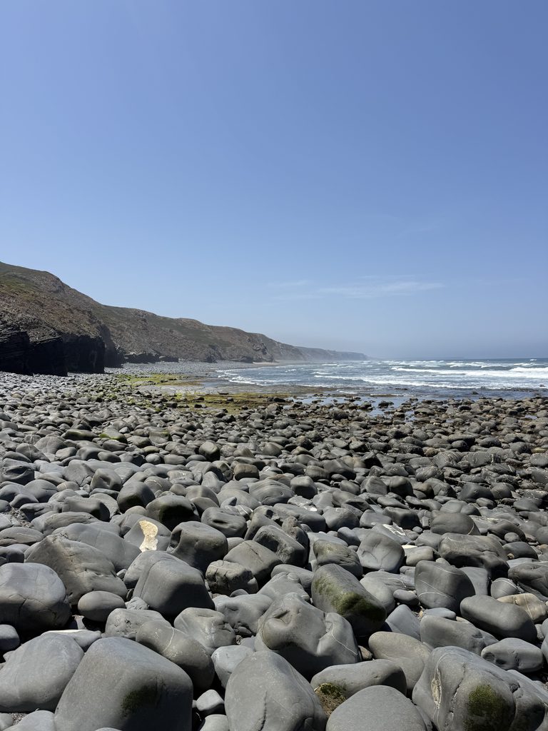 The rugged, rocky coastline and dramatic cliffs of Praia do Canal beach during a scenic 2-hour coastal hike in Aljezur.