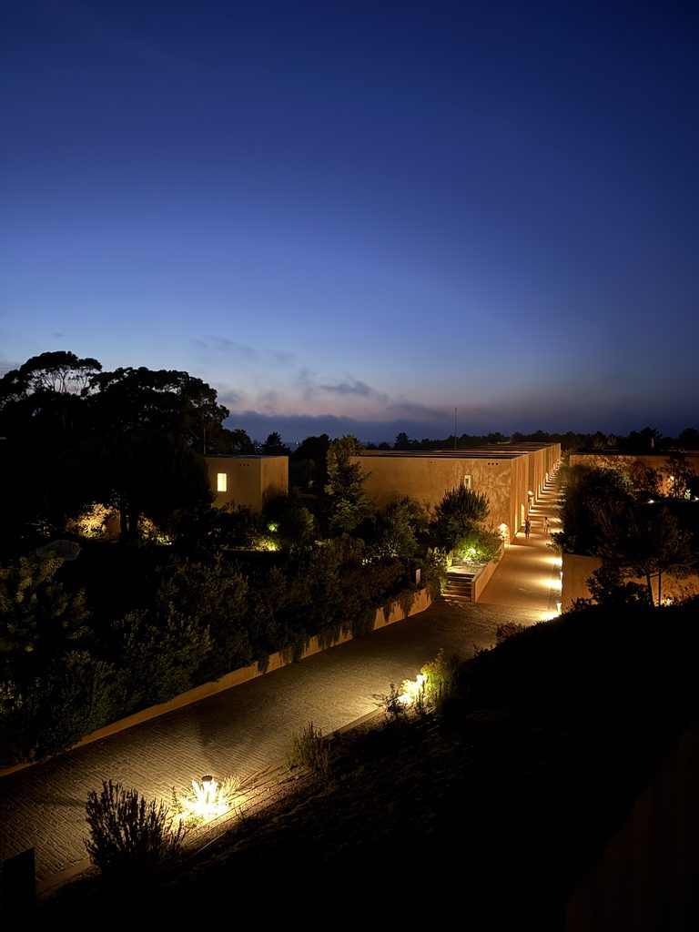 The modern, minimalist 5-star hotel rooms and architecture illuminated at dusk at Praia do Canal Nature Retreat.