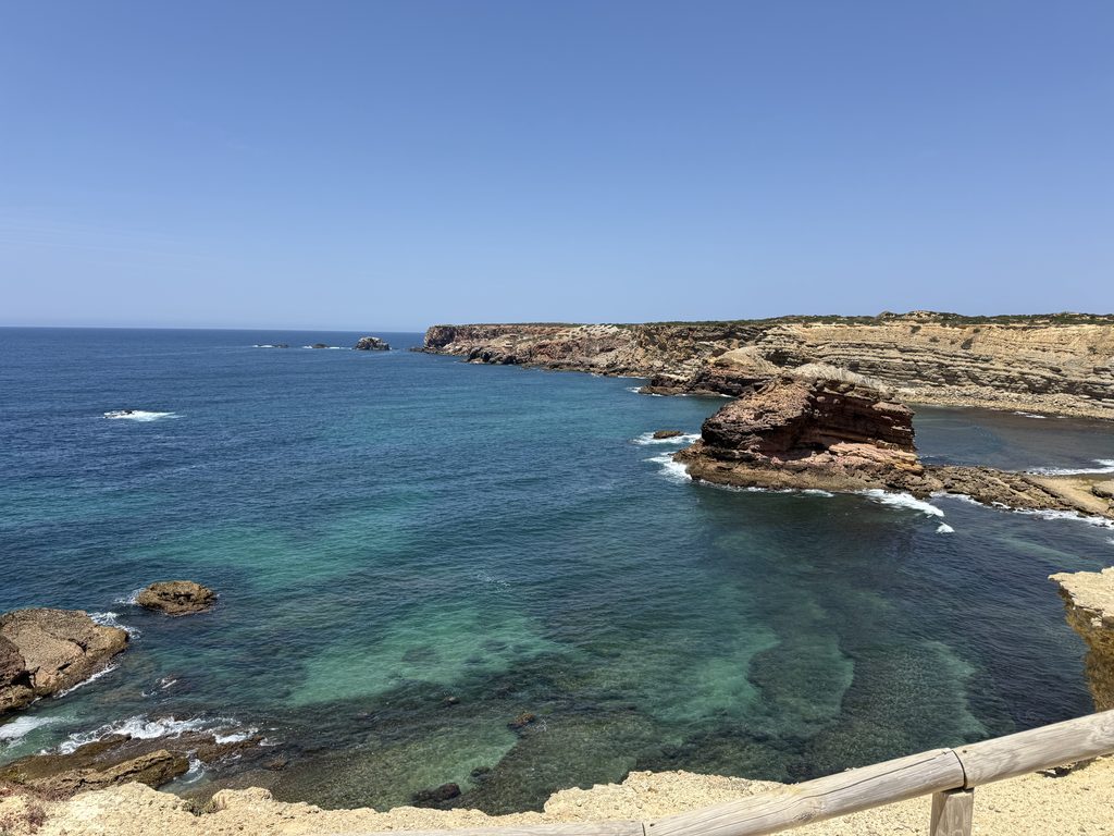 High-angle scenic view of the blue Atlantic Ocean, rolling cliffs, and beaches during a clifftop bike ride in Aljezur.